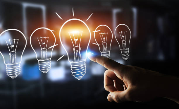 istock Businessman on blurred background drawing a lightbulb with a pen 1211277261
