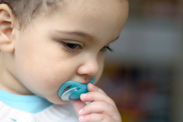 istock Baby Girl (1-2) Looking Pensive with Her Pacifier 121127795