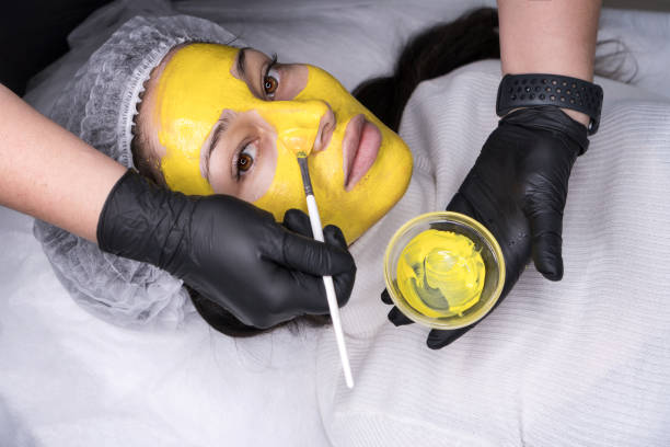 Facial retinol peeling Beauty salon, facial peeling mask with retinol treatment and fruit acids. Beautician apply mask on face of model. Cosmetology young girl therapy. Hyaluronic acid. Aesthetic Cosmetology concept facial chemical peel stock pictures, royalty-free photos & images