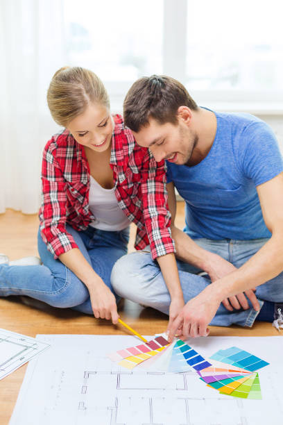 istock smiling couple looking at color samples at home 1211278646