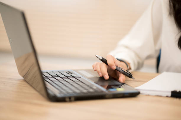 istock Asian working women wearing white shirts sitting at work desks. 1211278749
