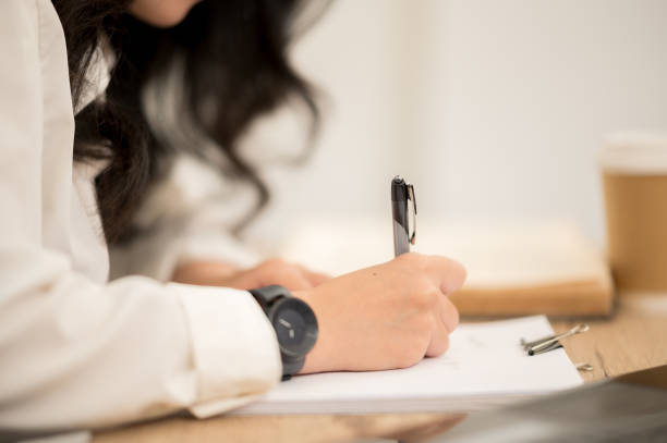 istock Asian working women wearing white shirts sitting at work desks. 1211278761