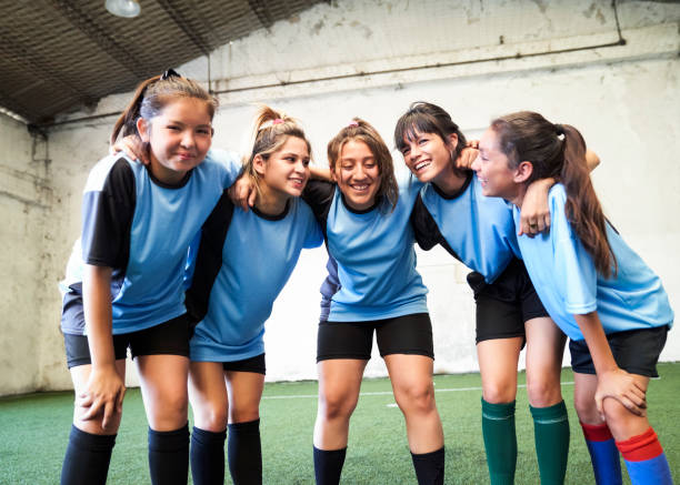 Female soccer team huddling after winning match