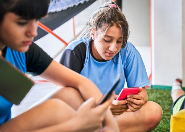 istock Soccer girl using cellphone after practice 1211280337
