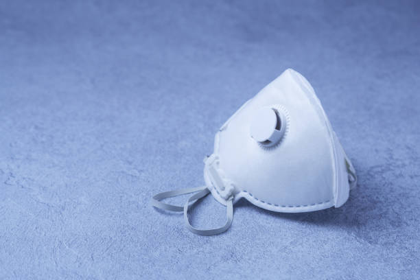 White ffp3 face mask with a valve Munich, Germany - March 8, 2020: A non reusable sterile white ffp3 mask with valve which can be used as a protection against viruses such as covid-19 corona virus, h1n1, h5n1 air valve photos stock pictures, royalty-free photos & images