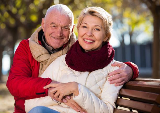 istock Mature couple sitting in park 1211281706