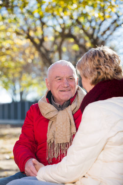 istock Mature couple talking in park 1211281707