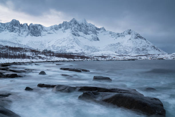 panorama von verschneiten fjorden und gebirge, senja, norwegen erstaunliche norwegen natur landschaft beliebte touristenattraktion. die besten berühmten reiseorte. schöner sonnenuntergang in der erstaunlichen winterlandschaft - mountain peak norway reflection sunlight stock-fotos und bilder