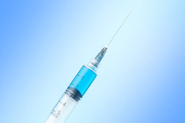 istock syringe with vaccine on blue background 1211284013