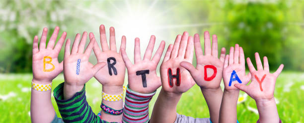 istock Children Hands Building Word Birthday, Grass Meadow 1211285198