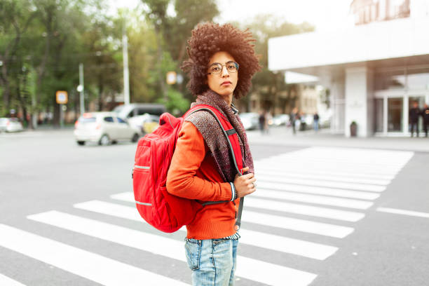 istock A young African American man with a red backpack crosses the road 1211285732