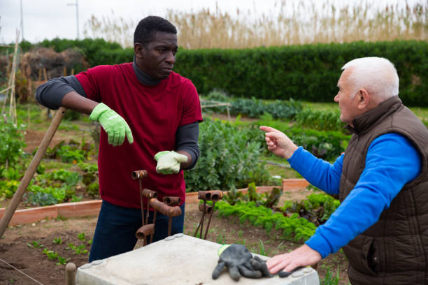 istock Two  smiling gardeners talking together in garden 1211287174