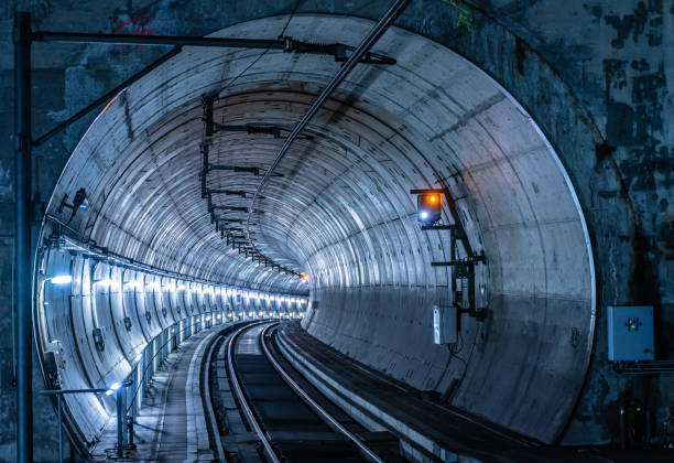 voies ferrées dans un tunnel éclairé - train tunnel photos et images de collection