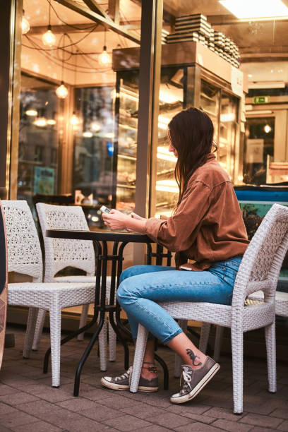 istock Brunette is sitting at cafe with mobile phone 1211288843