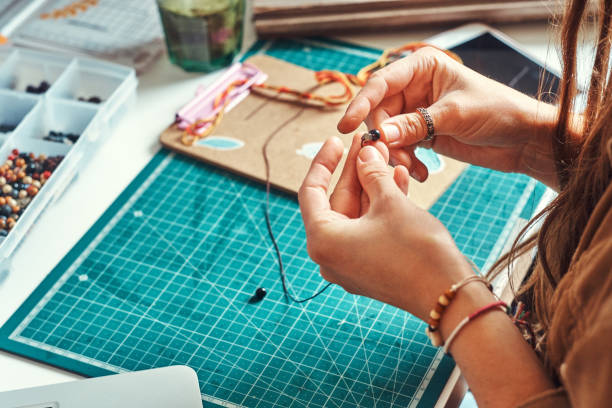 istock Girl is making jevellery from beads 1211291820