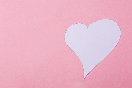 Heart shape hole on piece on pink paper