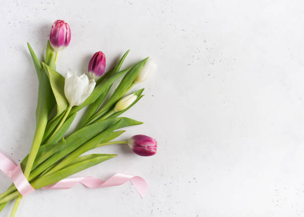 istock Tulips easter flat lay with pink and white flowers bouquet and eggs on white background. 1211294111