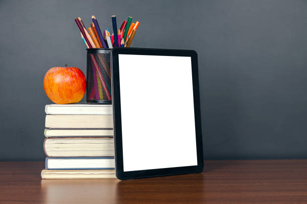 istock e-learning:Books and digital tablet on school desk with chalkboard 1211295525
