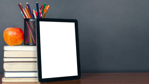 istock e-learning:Books and digital tablet on school desk with chalkboard 1211295586