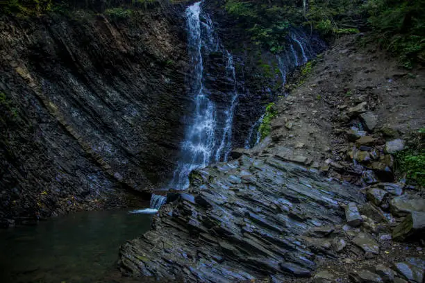 Photo of forest cascade waterfall cold rocky wood land scenic view with soft focus fuzzy water motion north nature region space