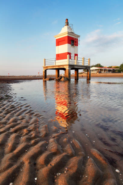 Beach with lighthouse in Italy resort Lignano at sunrise