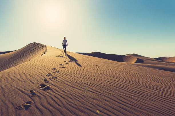 砂の中の足跡と砂丘の上の男 - desert landscape morocco sand dune ストックフォトと画像