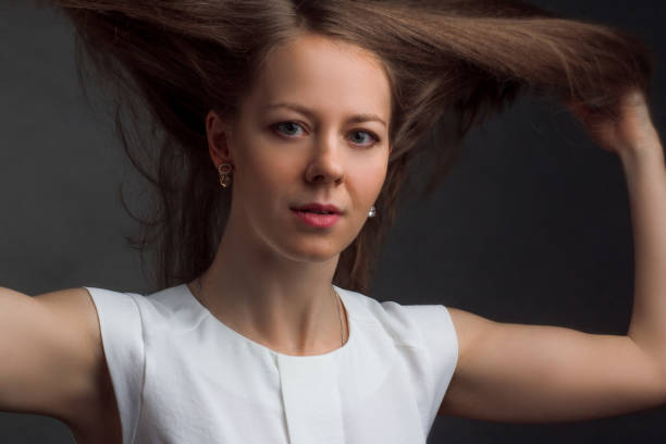 istock Studio portrait of a brunet in white blouse on a black background 1211303741