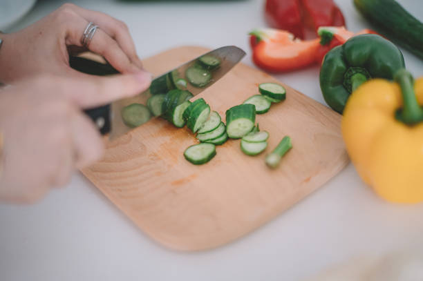 istock close up on hand cutting cucumber on the cutting board in the kitchen 1211304063