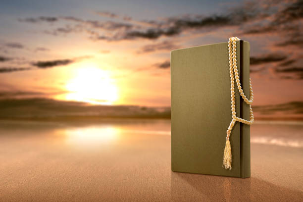 istock Quran and prayer beads on the sandy beach 1211304109
