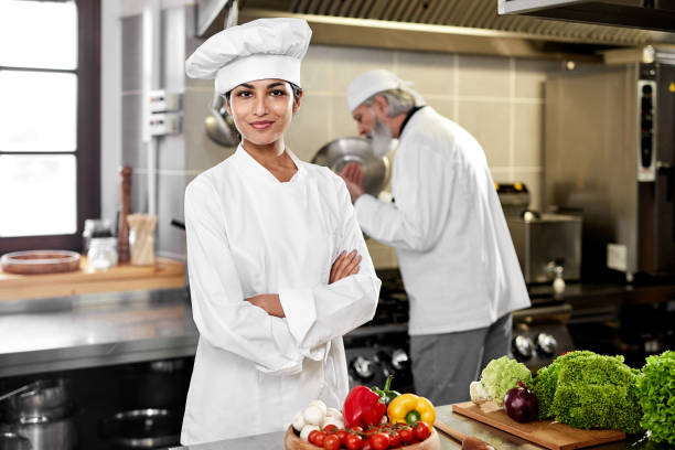 istock Professional female indian chef posing in the kitchen 1211304462