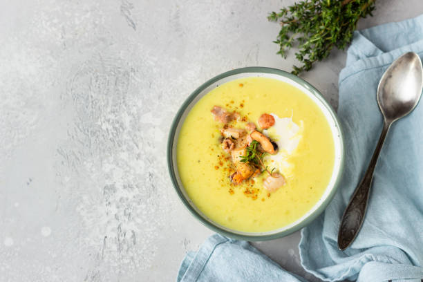 istock Thick milky chowder soup with seafood served with sour cream, thyme and pepper. Light grey stone background. Top view. 1211307659