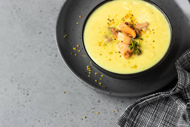 istock Bowl with thick clam chowder, decorated with seafood, thyme and pepper. Grey stone background. 1211308532