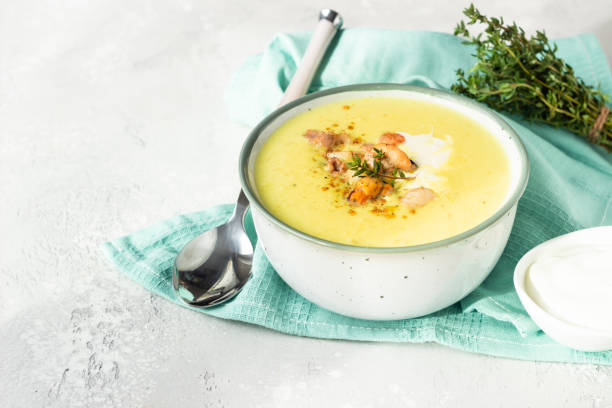 istock Thick milky chowder soup with seafood served with sour cream, thyme and pepper. Light grey stone background. 1211308579