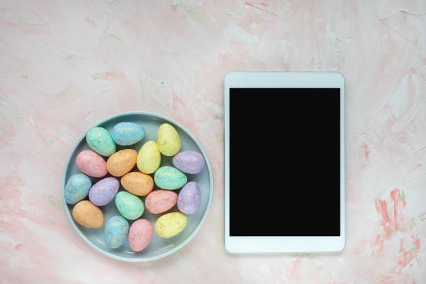 istock Eggs decoration and tablet on pink background 1211309885