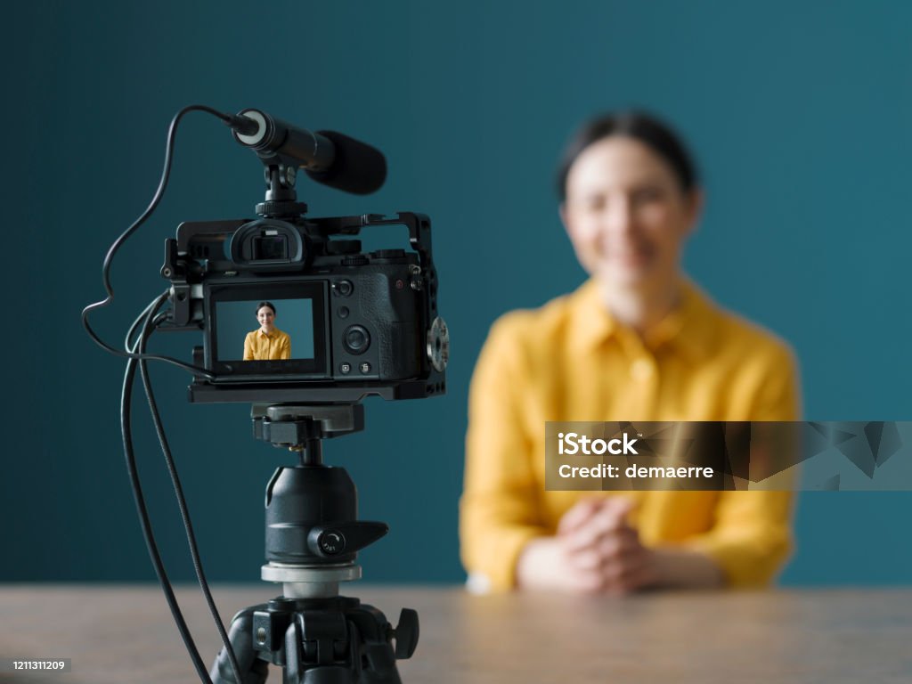 Vlogger profesional sentado frente a una cámara - Foto de stock de Cámara de vídeo libre de derechos