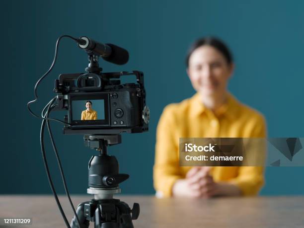 Vlogger Profesional Sentado Frente A Una Cámara Foto de stock y más banco de imágenes de Cámara de vídeo - Cámara de vídeo, Rodar, Mercadotecnia