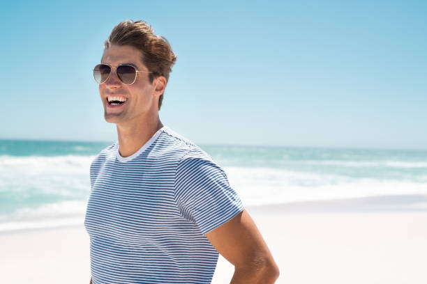 istock Happy man smiling at beach 1211311712