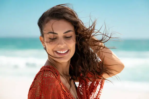 Photo of Beautiful latin woman enjoying wind at beach