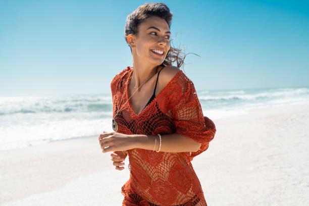 istock Glamour young woman running on tropical beach 1211312749