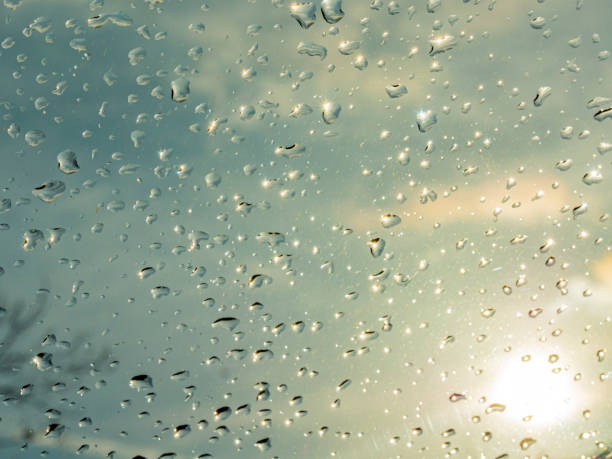 istock Wet window with rain drops and a cloudy sky outside. 1211315160