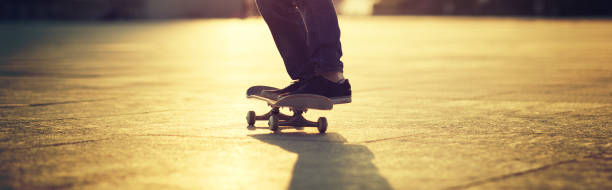 istock Skateboarder skateboarding at sunset city 1211318155