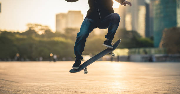 istock Skateboarder skateboarding at sunset city 1211318258