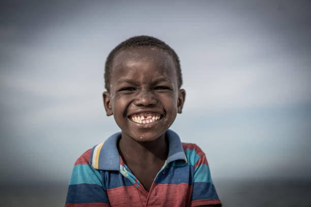 niño negro en la playa - africa child village smiling fotografías e imágenes de stock