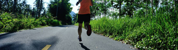 istock Woman runner running on tropical forest trail 1211320274