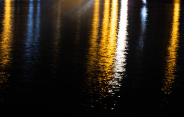 istock Colorful light reflection on the water surface at night. 1211321385