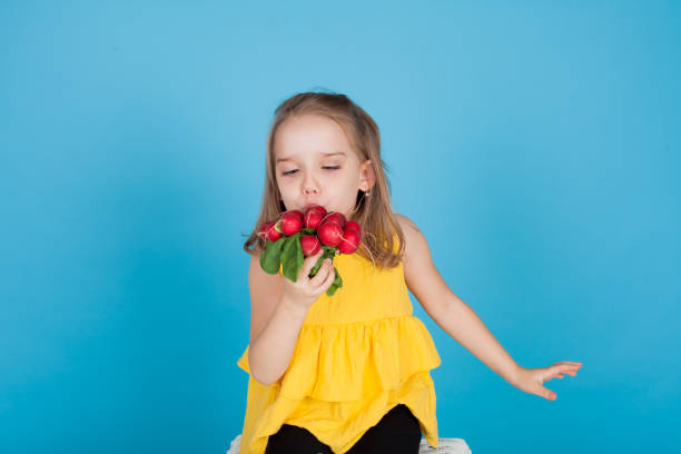 Beautiful girl holds vegetables red radish in her hand