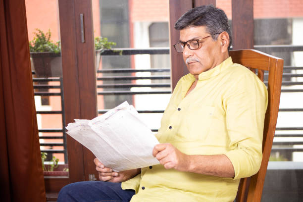 istock Senior Man Reading Newspaper and having coffee 1211321634