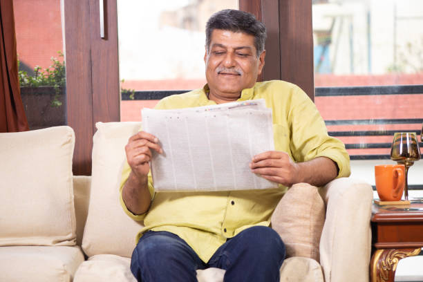 istock Senior Man Reading Newspaper and having coffee 1211321638