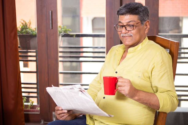istock Senior Man Reading Newspaper and having coffee 1211321671