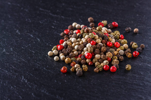 istock mix of peppercorns on a dark stone background 1211321704